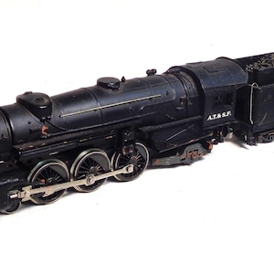 May include: A black model train with silver wheels and the number 199 on the coal car. The train has the letters "A.T.&S.F." printed on the side. The train is a detailed replica of a steam engine.
