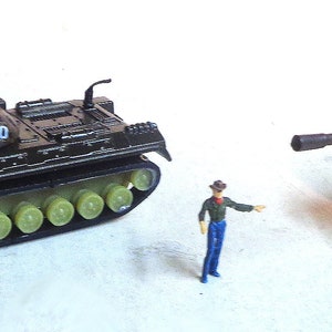 Puede incluir: Dos tanques de juguete con un esquema de pintura de camuflaje. Los tanques tienen una estrella roja en el lateral y los números 8120 y 8130 impresos en la parte superior. Los tanques son de color marrón claro y están sobre una superficie blanca.