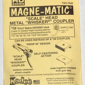 May include: Yellow and black packaging for HO scale #158 Magne-Matic coupler. The package includes diagrams and text describing the coupler's features, including a self-centering action and drop-in design. Made in the U.S.A.