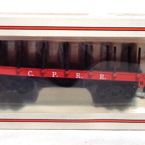 Puede incluir: Un vagón de tren modelo rojo y negro con las letras "C.P.R.R." impresas en el lateral. El vagón está en una caja blanca con el logotipo de Bachmann.
