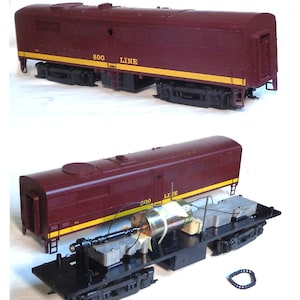 May include: A disassembled model train engine with a maroon body and black chassis. The engine is labeled "500 LINE".