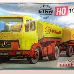 May include: A yellow and red model kit of a Shell tanker truck. The box features the Kibri logo, HO scale, and the model number 10 062. The truck has a Shell logo on the side and the text "Wackenhut" on the bottom.