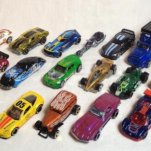 Könnte beinhalten: Eine Sammlung von 18 Spielzeugautos und -lastwagen, darunter ein Sattelzug, ein Rennwagen, ein Hot Rod und ein Pickup. Die Autos sind in verschiedenen Farben, darunter Rot, Blau, Grün, Gelb und Schwarz.