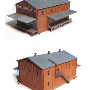 May include: A model of a brick building with a grey roof and a sign that reads "Golden Valley Canning Co."