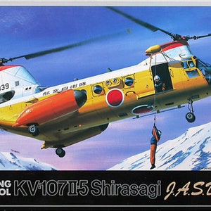 May include: A yellow and orange Boeing Vertol KV-107II-5 Shirasagi helicopter with the registration number 64-4839 and the text J.A.S.D.F. is shown in flight over a snowy mountain range. The helicopter is carrying a person on a rope.