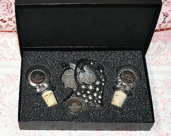 Set includes 2 Wine Stoppers and Grape Badge, all with The Sun Valley Logo - Brand New In Display Box, Never Used - Wine Serving Set