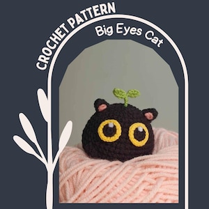 Puede incluir: Un gato negro tejido a ganchillo con grandes ojos amarillos y pequeñas hojas verdes en la parte superior. El gato tiene orejas internas rosas y está sentado sobre una bola de hilo rosa. El texto "CROCHET PATTERN Big Eyes Cat" está en el fondo.