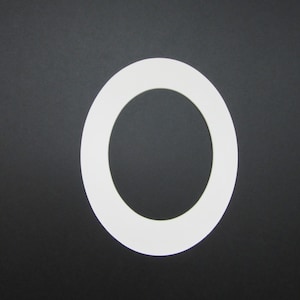 May include: A white circular frame with a large inner circle. The frame is made of a thick, smooth material and has a slightly raised edge.