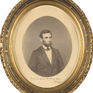 K&ouml;nnte beinhalten: Ovales Sepia-Portr&auml;t von Abraham Lincoln in einem goldenen, verzierten Rahmen. Das Foto zeigt Lincoln in einem dunklen Anzug, wei&szlig;em Hemd und Fliege. Der Rahmen hat einen schwarzen Akzent und die Inschrift "To my good friend, Mrs. Fanny Speed. Lincoln."