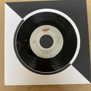 May include: A black 45 RPM vinyl record with a white label. The label features a red, white, and blue star with the text "BURNING LIKE A ROCKET" and "BILLY JOE ROYAL".