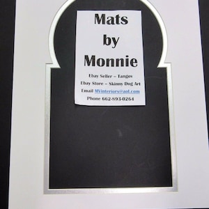 May include: White mat with a silver border and an arched opening. The mat has a black background with white text that reads "Mats by Monnie, Ebay Seller - Tangov, Ebay Store - Skinny Dog Art, Email MVinteriors@aol.com, Phone 662-893-0264".