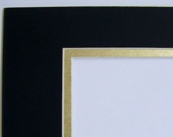 May include: A black mat with a gold border. The mat is designed to be used for framing photos or artwork.