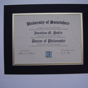 May include: A framed diploma from the University of Somewhere awarded to Jonathan Q. Public for a Doctor of Philosophy degree. The diploma is on a beige background with black text and a gold border.