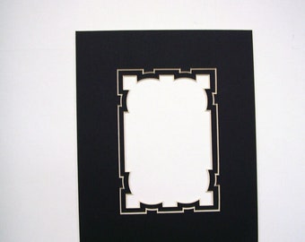 May include: A black picture mat with a decorative, scalloped opening. The mat is rectangular with a white interior border. The background is plain white.