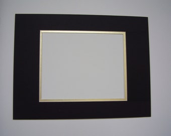 May include: Black mat board with a gold border, creating a picture frame.