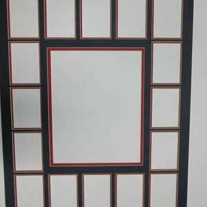 May include: A black picture frame with multiple openings for photos. The frame has a large central opening surrounded by smaller rectangular openings. Each opening has a white background and a red border.