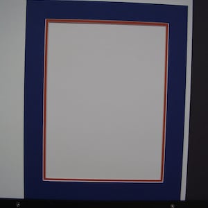 May include: A navy blue picture frame with a red inner border. The frame is empty.