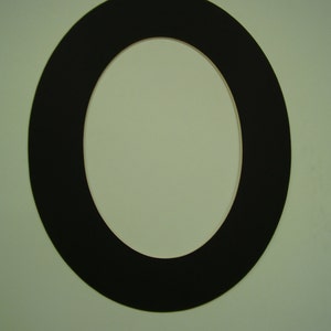 May include: A black oval picture frame with a white mat.