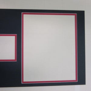May include: A black picture frame mat with two rectangular openings. The larger opening is on the right and the smaller opening is on the left. Both openings are bordered by a thin red accent line, framing the white space within the mat board.