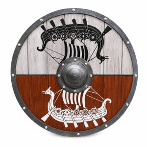 Puede incluir: Un escudo circular de madera con un borde de metal y un umbo central de metal. La mitad superior es de color gris claro con un gr&aacute;fico de barco vikingo negro, mientras que la mitad inferior es de color marr&oacute;n oscuro con un gr&aacute;fico de barco vikingo blanco, asegurados con remaches met&aacute;licos.