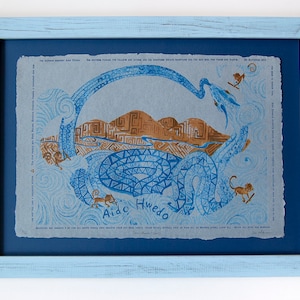 May include: A framed print of a blue and brown illustration with a snake, mountains, and monkeys. The text "Aido Hwedo" is printed below the image.
