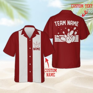 Può includere: Una camicia a maniche corte con bottoni in rosso scuro e bianco. Il davanti presenta un pannello verticale bianco con una grafica di birilli da bowling e il testo NAME. Il retro mostra una grande grafica bianca di birilli e una palla con il testo TEAM NAME.