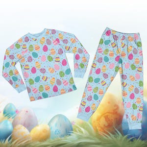 May include: A light blue pajama set featuring a repeating pattern of colorful Easter eggs. The long-sleeved top and pants have a matching design with eggs in various colors, including pink, yellow, green, and blue. The pajama set is designed for comfort and seasonal celebrations.