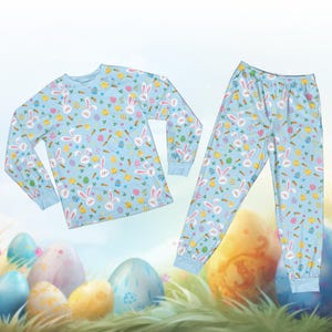May include: A light blue pajama set featuring a repeating pattern of white Easter bunnies, carrots, eggs, and chicks. The long-sleeved top and pants have blue cuffs and a relaxed fit, perfect for Easter celebrations.