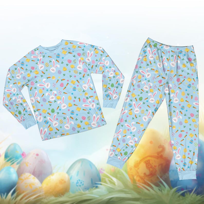 May include: A light blue pajama set featuring a repeating pattern of white Easter bunnies, carrots, eggs, and chicks. The long-sleeved top and pants have blue cuffs and a relaxed fit, perfect for Easter celebrations.