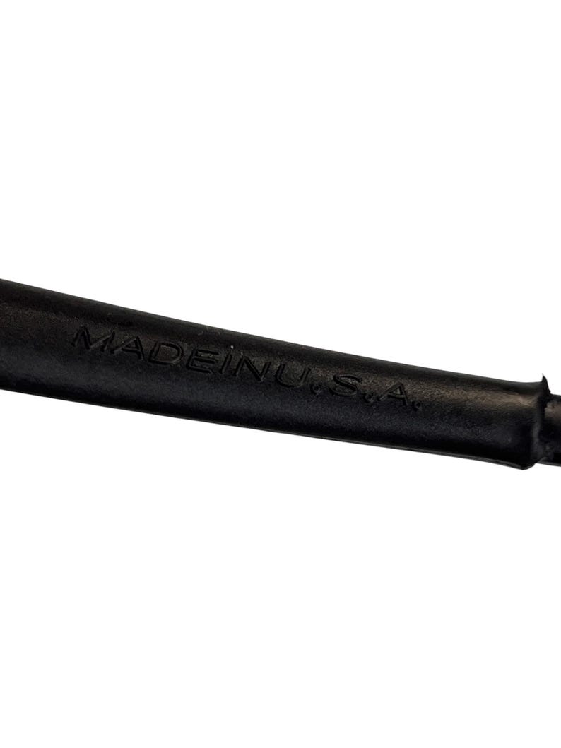 May include: Close-up of a black object with the text "MADE IN U.S.A." embossed on its surface. The object appears to be made of a flexible material.