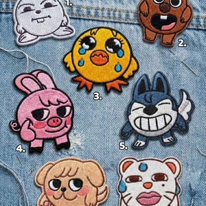 May include: Embroidered patches featuring cartoon animals, including a bunny, bear, chick, pig, dog, and cat. Each patch has a unique design with vibrant colors and detailed stitching. The patches are displayed on a denim background.