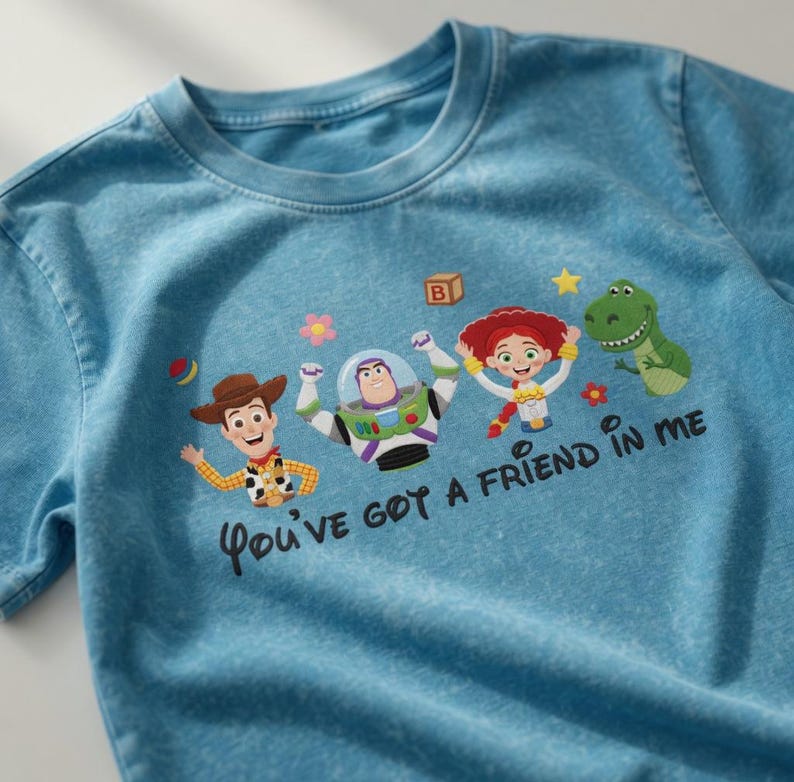Puede incluir: Camiseta azul claro con personajes de Toy Story. La camiseta tiene un dise&ntilde;o de Woody, Buzz Lightyear, Jessie y Rex, con el texto "You've got a friend in me".