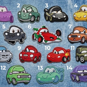 Könnte beinhalten: Sammlung von vierzehn gestickten Autoaufnähern in verschiedenen Farben, darunter Lila, Grün, Schwarz, Gelb, Weiß, Rot und Blau. Jeder Aufnäher zeigt ein einzigartiges Autodesign mit ausdrucksstarken Gesichtern.