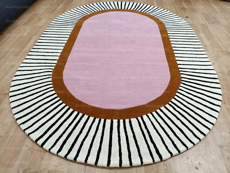Pu&ograve; includere: Tappeto ovale con centro rosa, bordo marrone e bordo esterno a righe bianche e nere. Il design del tappeto &egrave; moderno e adatto a un soggiorno o una camera da letto. Lunghezza: circa 180 cm.