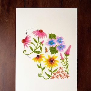 May include: A watercolor illustration of a floral arrangement in the shape of a state. The artwork features pink, yellow, and purple flowers, green leaves, and a small orange butterfly. The artist's signature is visible.