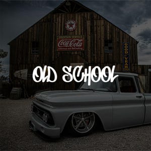 Op de afbeelding: Een vintage grijze pick-up truck staat voor een verweerde houten schuur. De afbeelding bevat de tekst "OLD SCHOOL" in een gestileerd lettertype. De schuur heeft Coca-Cola- en benzineborden.