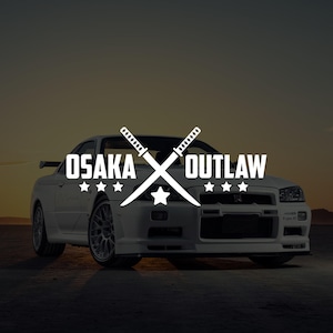 May include: White sports car with the text "OSAKA OUTLAW" and a crossed swords logo. The car is parked on a dark surface with a sunset background. The logo includes stars and a star.