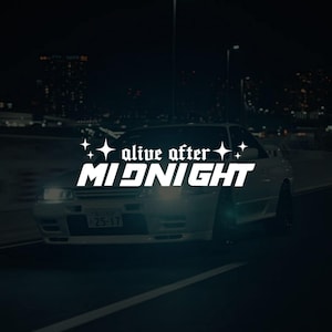 Op de afbeelding: Een witte auto rijdt 's nachts op een donkere weg. De tekst "alive after MIDNIGHT" staat in witte, gestileerde letters over de auto. De koplampen van de auto zijn aan en de achtergrond toont stadslichten.