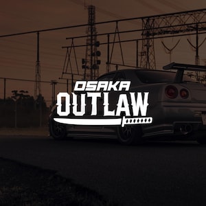 May include: A silver sports car with a rear spoiler is parked on a dark road. The text "OSAKA OUTLAW" is displayed in white, with a sword graphic. The background features power lines and a muted sky.