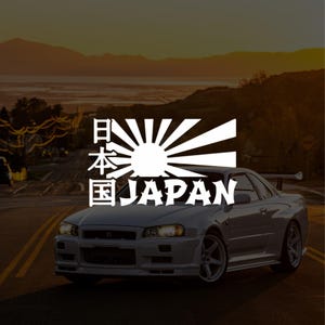 May include: A white sports car with a spoiler on a road. A white graphic of the Japanese flag with the text "JAPAN" is overlaid on the car. The background shows a sunset over water and mountains.