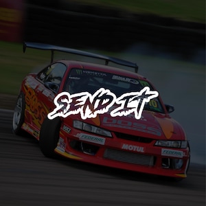 May include: A red sports car with a black spoiler is shown in motion. The car has sponsor logos and the text "SEND IT" in a white, stylized font. The car is on a racetrack.