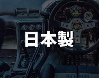 May include: Interior view of a car's dashboard, featuring a steering wheel, gauges, and gear shift. The text "Made in Japan" is prominently displayed in white. The overall aesthetic suggests a focus on automotive design and craftsmanship.