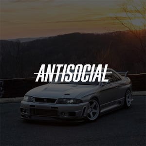 Peut inclure: Une voiture de sport argentée avec des roues blanches et un aileron arrière, présentant le mot ANTISOCIAL en lettres capitales blanches grasses avec une ligne horizontale au centre, positionné au-dessus du capot et du pare-brise.