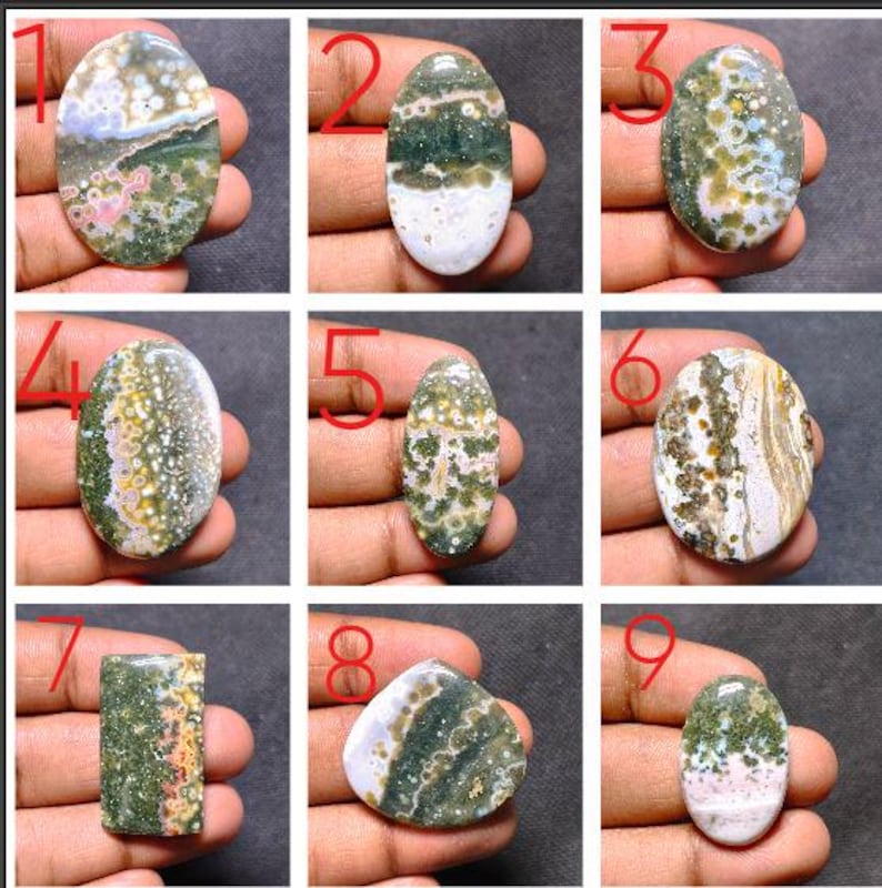 May include: A collection of nine polished ocean jasper cabochons in various shapes, including oval, rectangular, and triangular. Each stone features unique patterns of green, white, pink, and yellow orbicular inclusions and mineral banding.