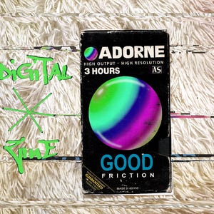 May include: A black box with the word "ADORNE" and "GOOD FRICTION" printed on it. The box features a colorful sphere with green, blue, and purple hues. Text on the box reads "HIGH OUTPUT - HIGH RESOLUTION" and "3 HOURS".
