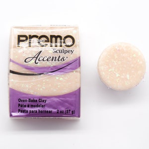 May include: A 2 ounce (57 gram) pack of Premo Sculpey Accents oven-bake clay in a pearlescent white colour with iridescent glitter.
