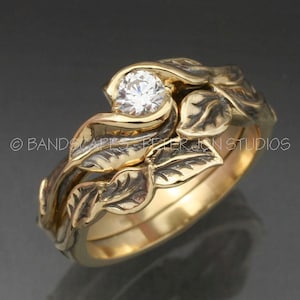 Puede incluir: Un juego de alianzas de boda de oro con un solitario de diamante en un diseño de hoja.