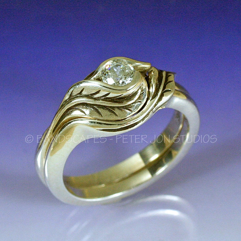 May include: A gold wedding band set with a diamond set in a leaf design.