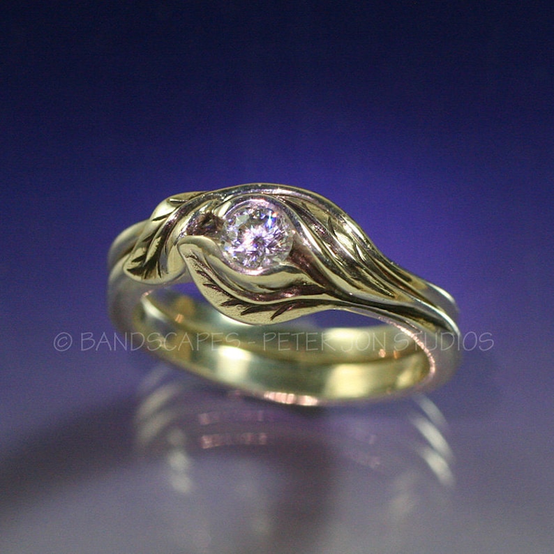 May include: A gold ring with a single round diamond set in a leaf design. The ring is made of two bands, one of which is twisted around the other.
