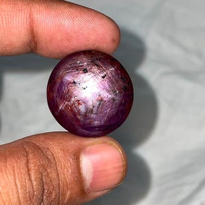 Rubis étoilé naturel, gros cabochon rond, astérisme à 6 rayons.